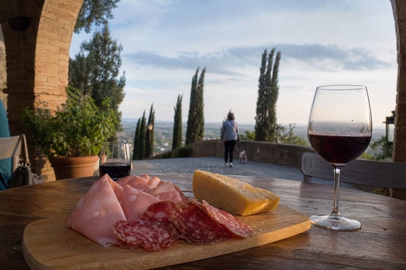 Slices of salami, mortadella and cheese with a glass of deep red Lambrusco in a Castelvetro di Modena cellar