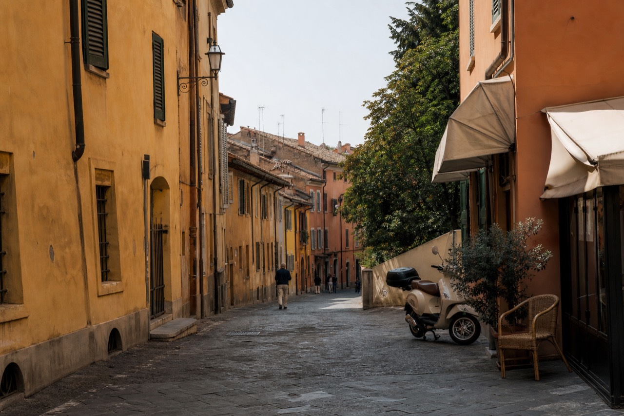 A quiet Modena street with ochre buildings and bicycles parked beside a cafe awning