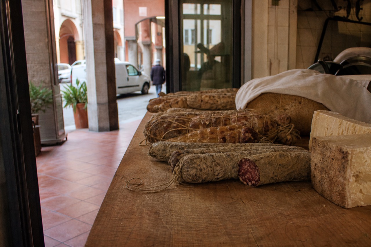 Cured meats and cheese on a wooden counter in an Italian food shop