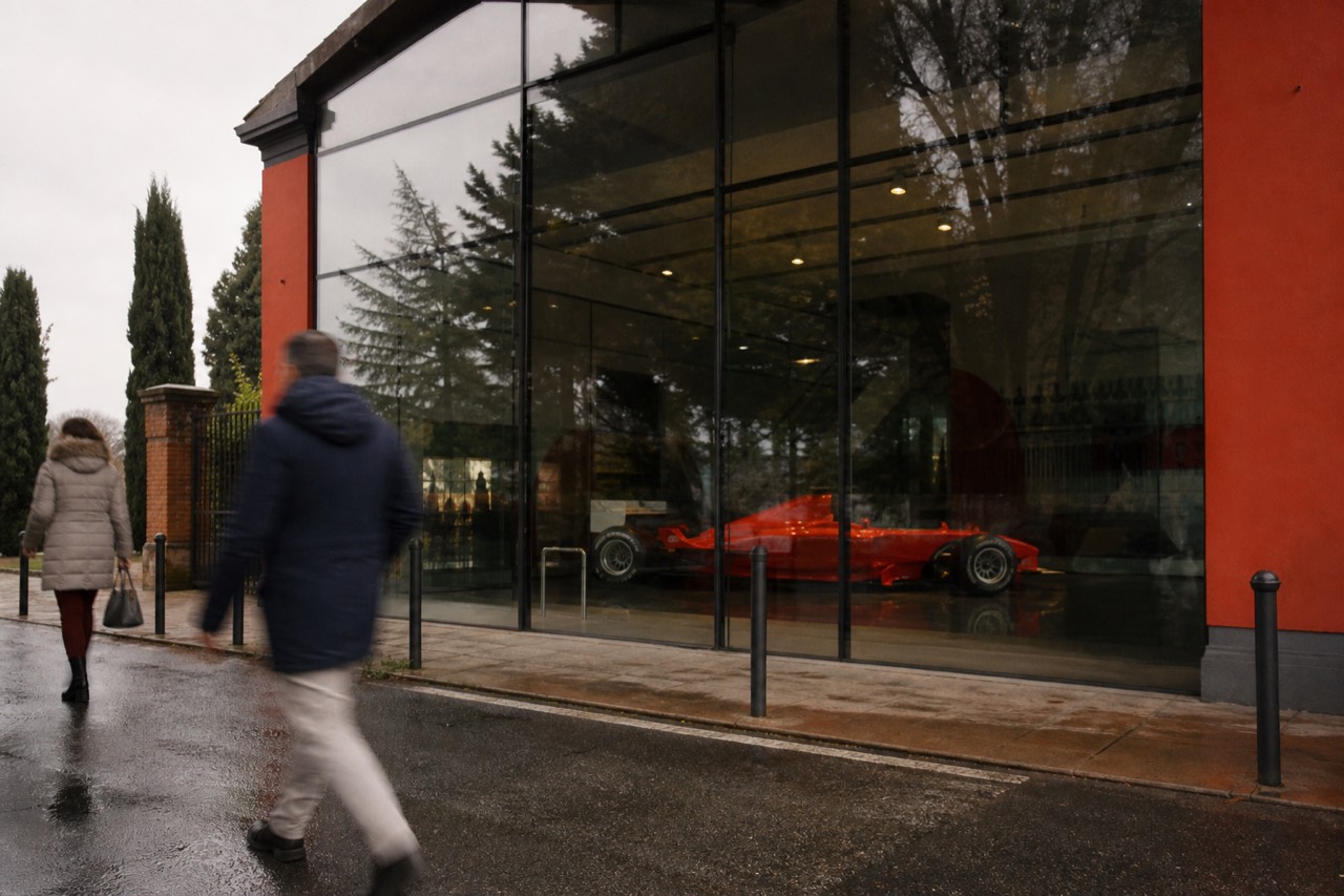 Ferrari Museum entrance in Maranello with a red Formula 1 car on display and visitors walking past