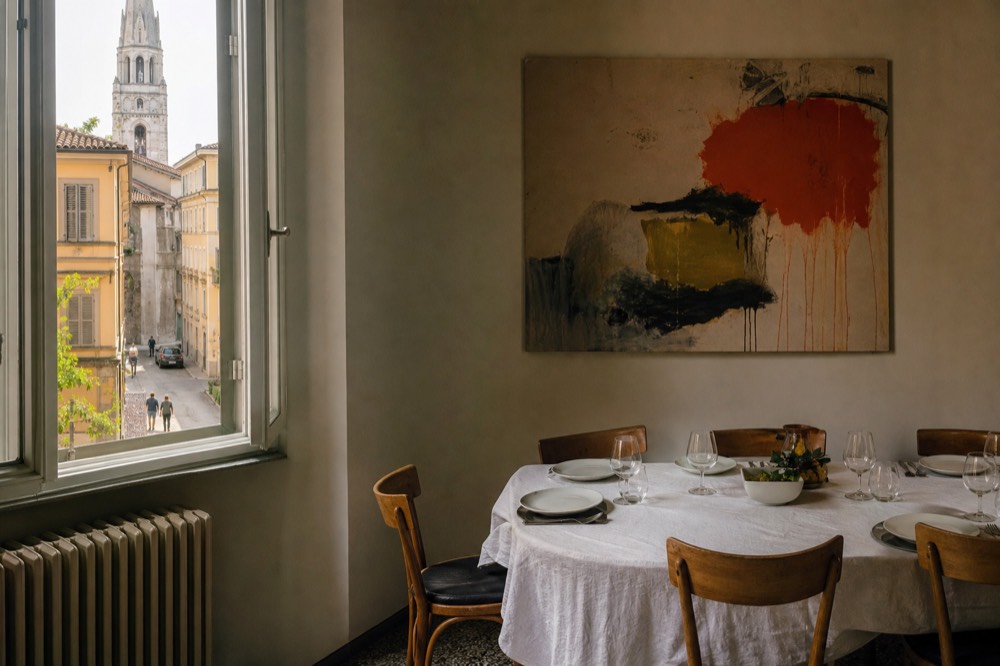 Dining room corner with contemporary art on a pale wall above a set table