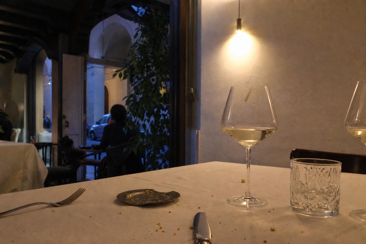 Set table with white linen and wine glasses in a quiet Modena dining room