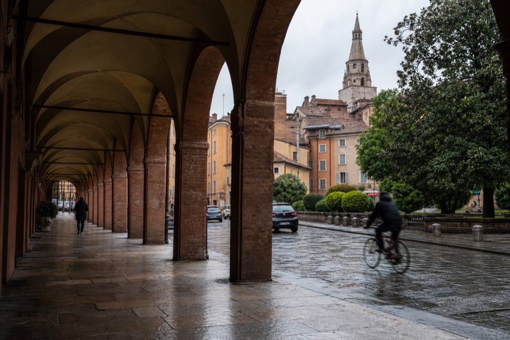 A quiet Renaissance street with arcades and brick buildings in an Italian town
