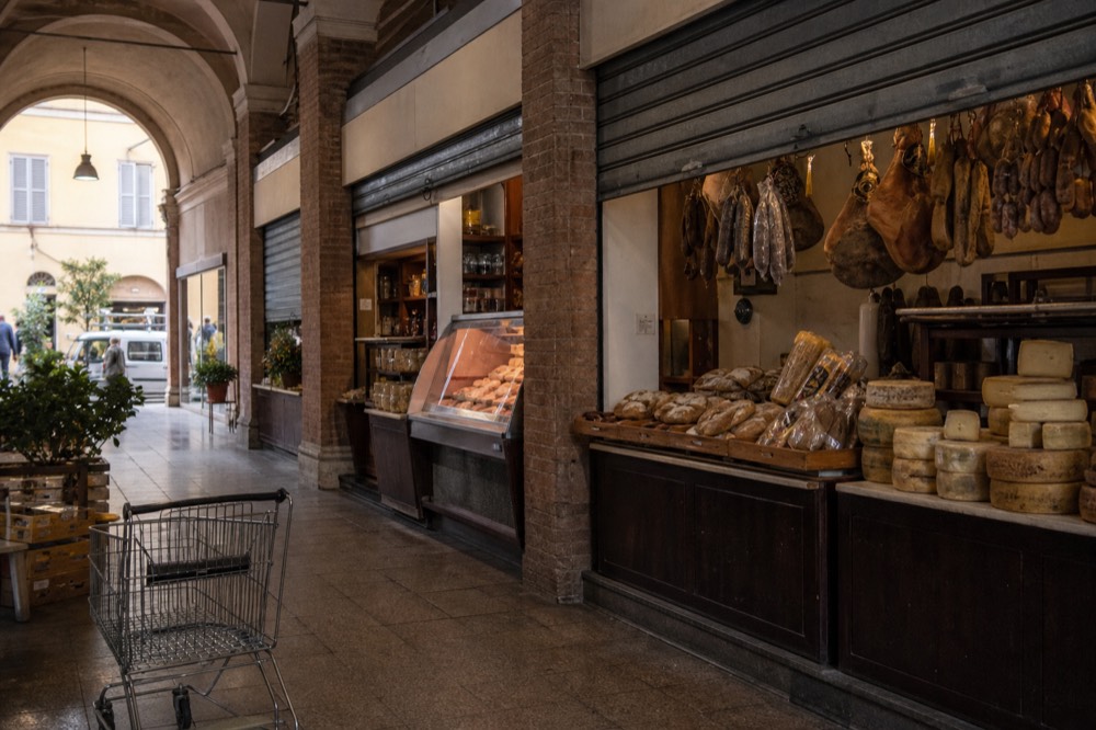 An old market hall with stalls of cheese, cured meats and bread
