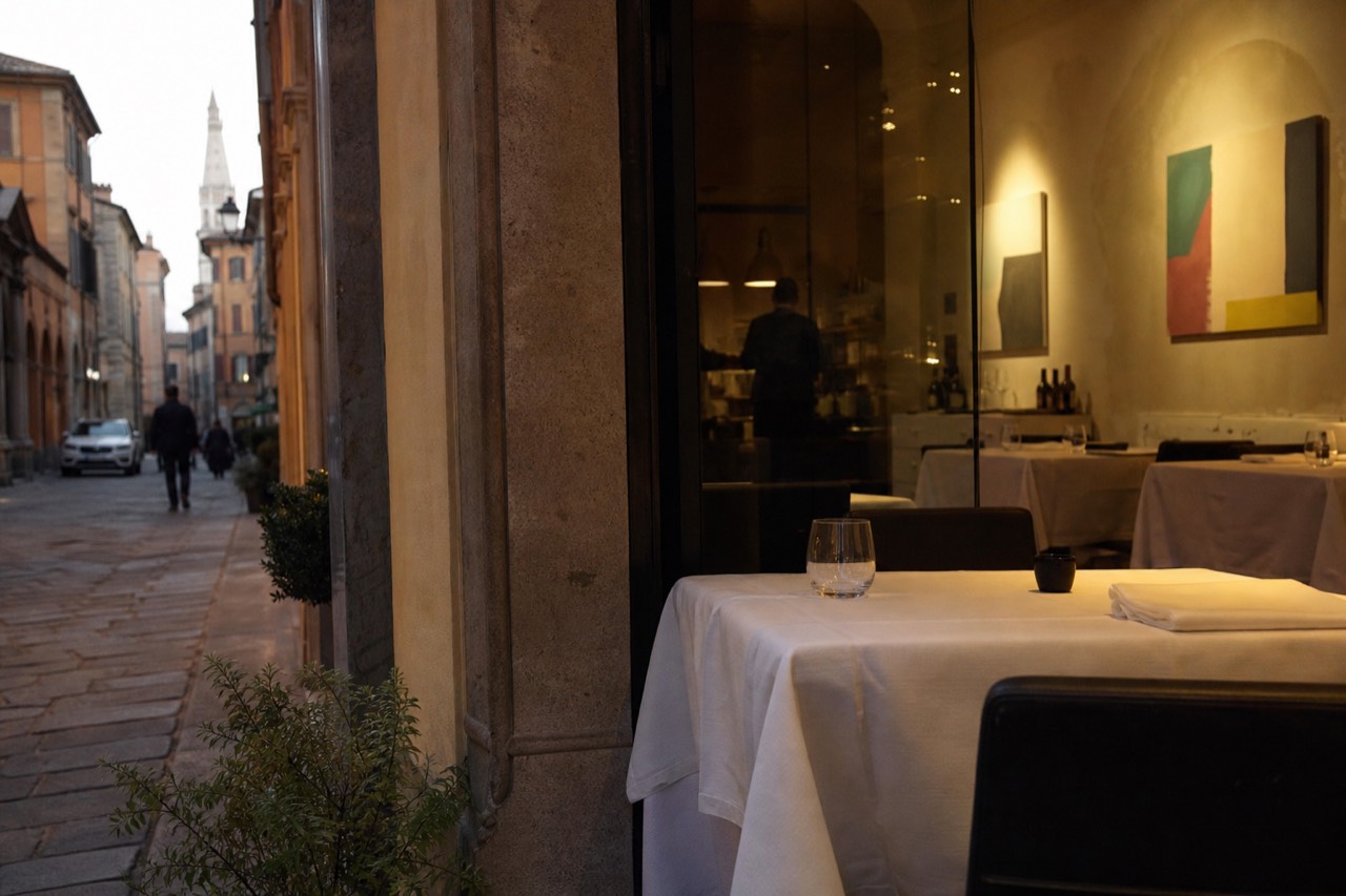 A dining room with white tablecloths and modern artwork on the walls