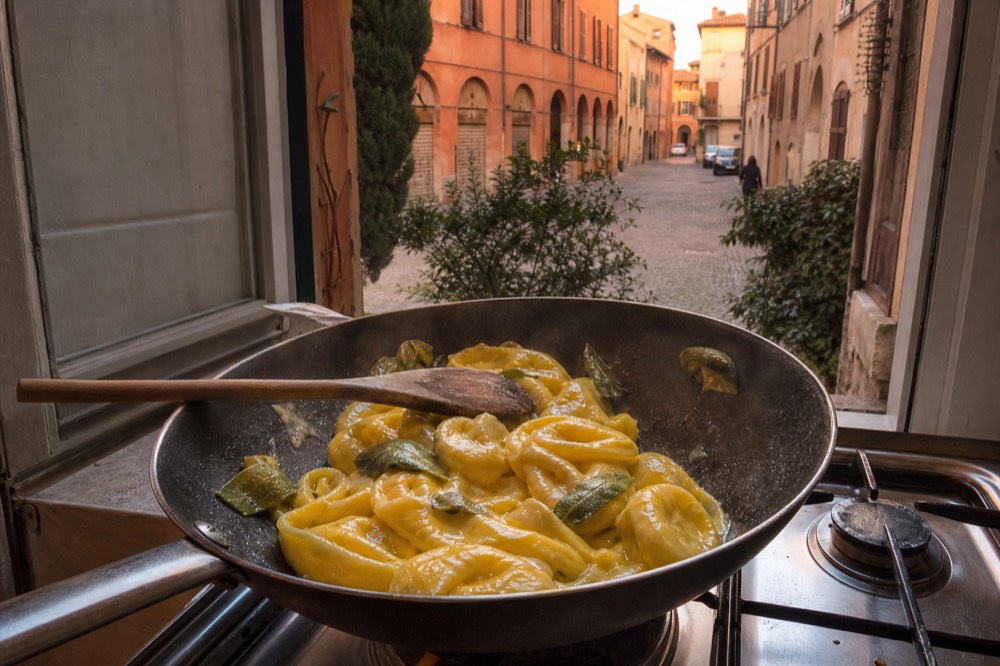 Ricotta tortelloni tossed with melted butter and sage leaves in a pan