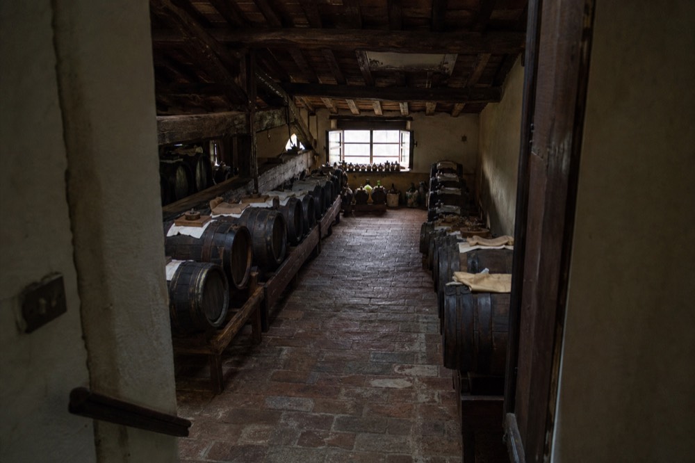 Rows of wooden ageing barrels in a dim vinegar loft
