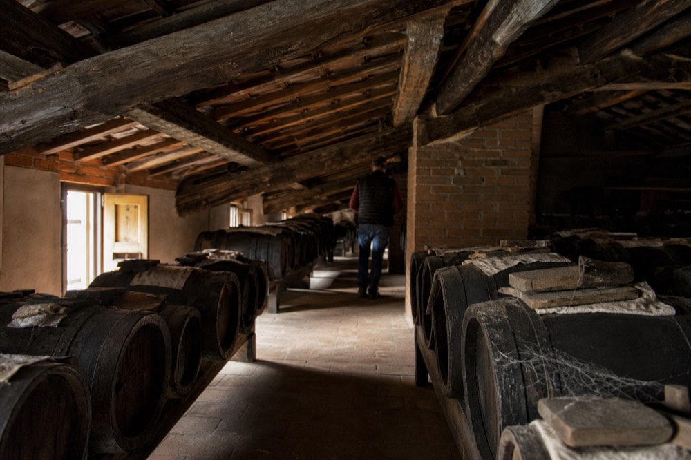 Rows of small wooden ageing barrels in a traditional balsamic vinegar loft