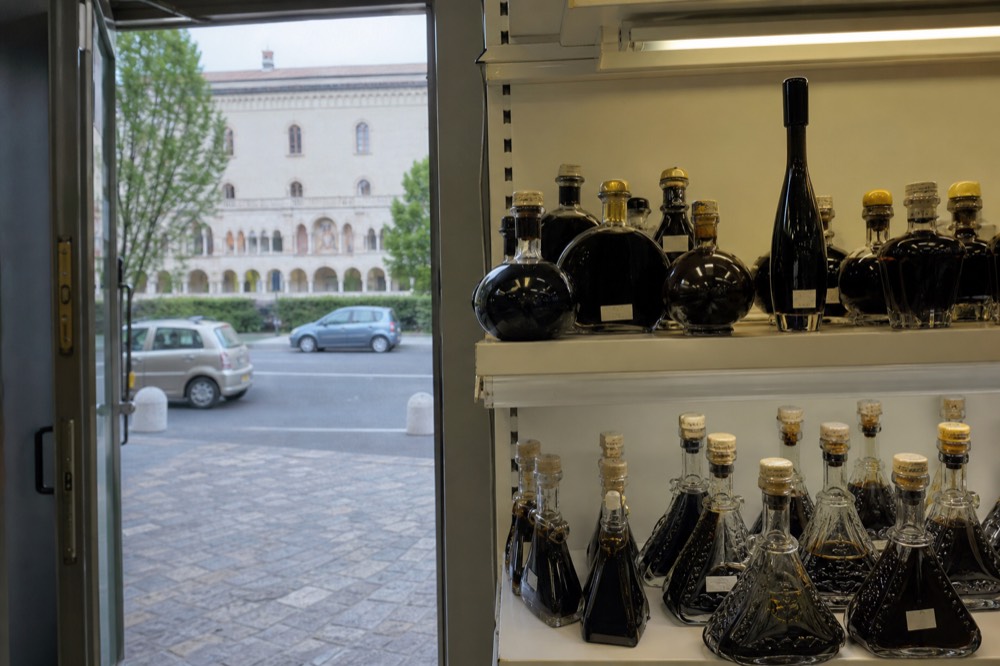 A shelf of balsamic vinegar bottles at an airport shop with the Giugiaro bottle visible among decorative ones