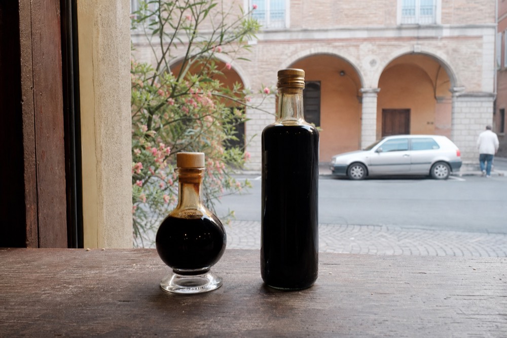 Two bottles side by side: one DOP Giugiaro with seal, one IGP glass bottle with EU PGI logo