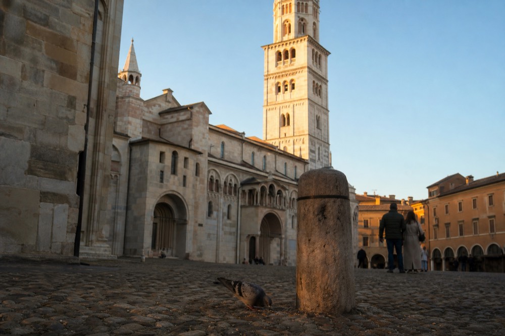 A cathedral square with a stone bell tower rising above rooftops