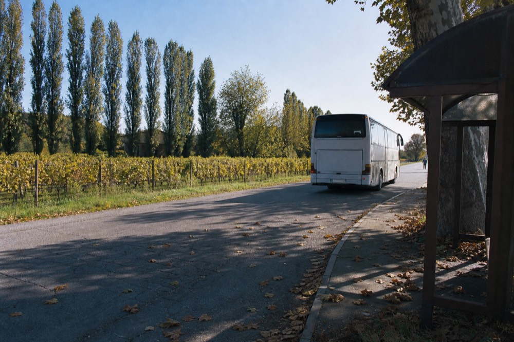 A regional bus parked at a small station stop in the Modena countryside