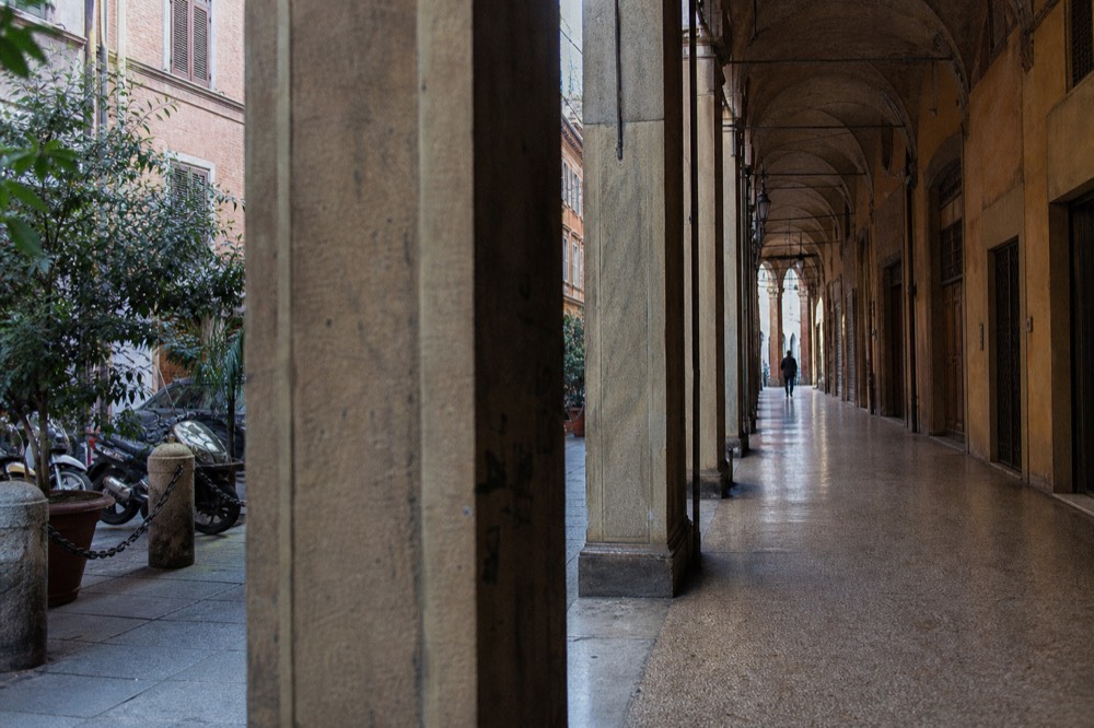 A historic covered passage in Modena with arched ceilings and soft daylight