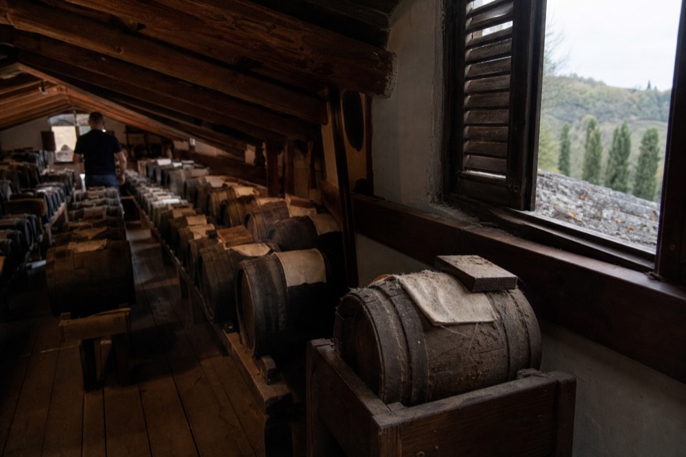 Wooden barrels of different sizes inside a traditional balsamic vinegar ageing loft