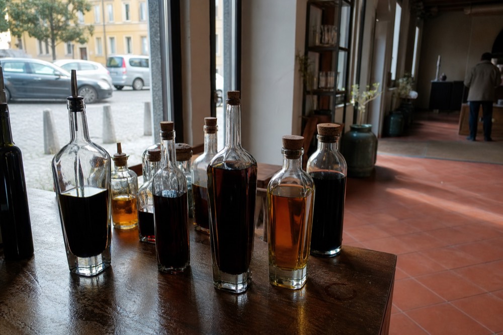 Bottles of balsamic vinegar of Modena IGP lined up on a producer's tasting counter