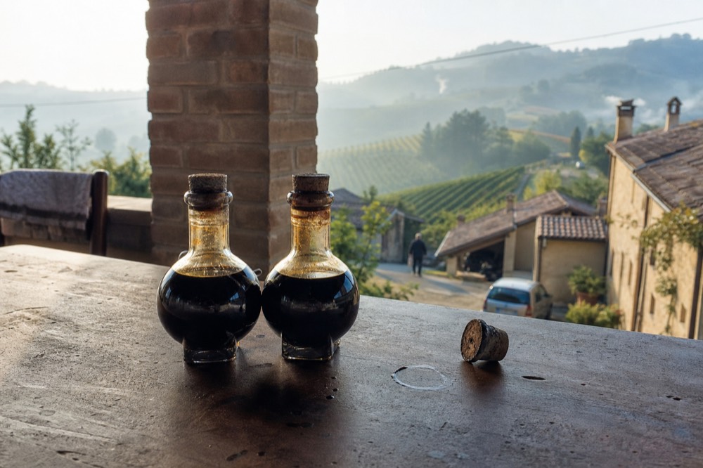 Two different balsamic vinegar bottles standing side by side on a tasting table