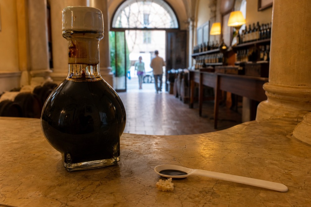A close view of a sealed spherical balsamic bottle with its numbered seal on a tasting counter