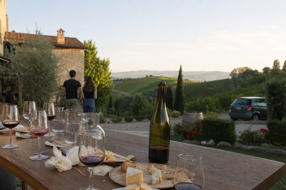 A tasting table set with small glasses of balsamic vinegar and local cheeses at an acetaia