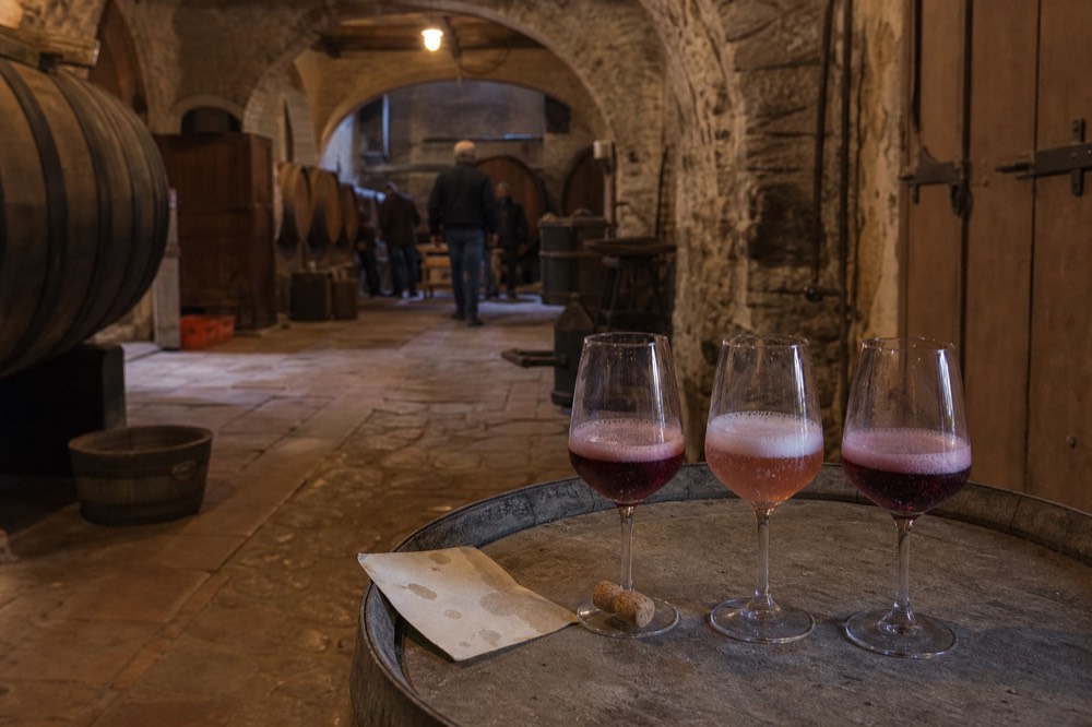 Three glasses of dark and pale Lambrusco on a cellar barrel