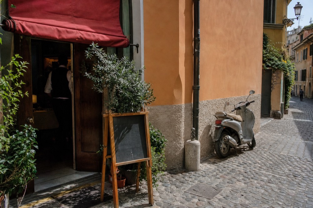 A street-level sign reading 'Osteria' with a menu board outside